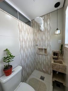 un bagno con un water e una pianta in vaso di Charmoso apt Milao c garagem no centro a Serra Negra Altre 7 foto