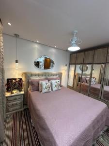 una camera da letto con un letto grande e uno specchio di Charmoso apt Milao c garagem no centro a Serra Negra
