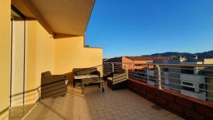 a balcony with a table and chairs on a building at Ultimo piano con terrazzo e posto auto in Zola Predosa
