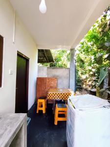 a room with a bench and a table and stool at Villa lovely birds mirissa in Mirissa