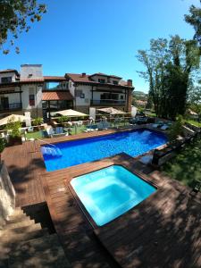 a large swimming pool with a wooden deck at Hotel Cuevas - Adults Only in Santillana del Mar