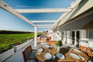 un patio con tavolo e sedie su un ponte di Villa Verso Comporta - NEW! a Monte da Carrasqueira