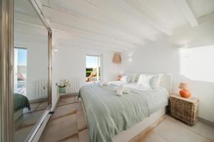una camera da letto bianca con un letto e una finestra di Villa Verso Comporta - NEW! a Monte da Carrasqueira Altre 37 foto