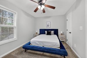 a bedroom with a blue bed and a ceiling fan at Inviting 2BR hideaway with contemporary touches in Clarksville