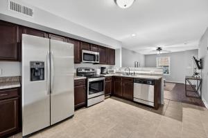 a kitchen with brown cabinets and white appliances at Inviting 2BR hideaway with contemporary touches in Clarksville