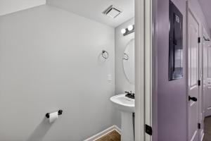 a white bathroom with a sink and a mirror at Inviting 2BR hideaway with contemporary touches in Clarksville +12 photos