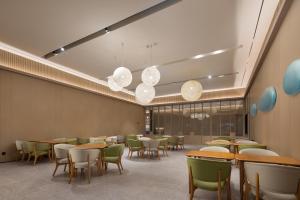 een eetkamer met tafels, stoelen en lampen bij JI Hotel Wuhan Guanggu 3rd Road in Wuhan