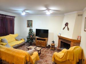 a living room with a couch and a christmas tree at CASA EL LAUREL in Vélez-Rubio
