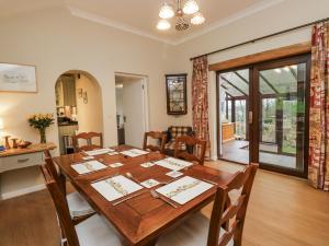 ein Esszimmer mit einem Holztisch und Stühlen in der Unterkunft Beech Brae in Kendal