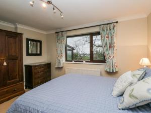 ein Schlafzimmer mit einem Bett und einem Fenster in der Unterkunft Beech Brae in Kendal