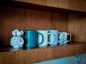 Ferienwohnung Doppelreiter في ابسي: صف من أكواب القهوة الزرقاء والبيضاء على الرف