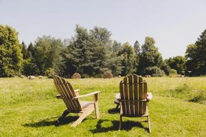 Dos sillas sentadas en el césped de un campo. en Parcel Tiny House I Richecourt vue Prairie, en Mesbrecourt-Richecourt