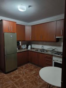 eine Küche mit Holzschränken und einem Edelstahlkühlschrank in der Unterkunft CASA EL LAUREL in Vélez Rubio
