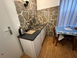 a small kitchen with a counter and a table and a stove at Landhotel Waldschänke in Berlin