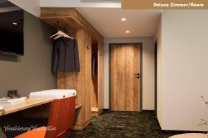 a room with a desk and a wooden door at Hotel Zur Post in Ismaning +35 photos