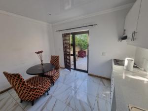 una cucina con un tavolo e sedie in una stanza di Bird Whistle a Zeekoevlei