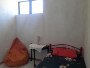 una camera da letto con un letto con un tavolo e una finestra di Bird Whistle a Zeekoevlei