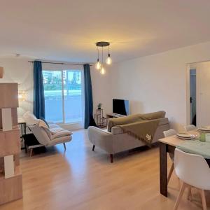 a living room with couches and chairs and a table at La Varangue bleu T3 Aéroport Sainte Marie in Sainte-Marie +11 photos