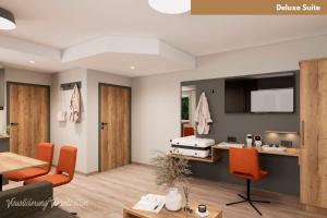 a living room with a bed and orange chairs at Hotel Zur Post in Ismaning