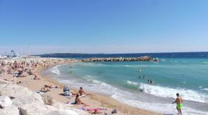 Chambres charmantes dans un appartement moderne à deux pas de la mer في كان: مجموعة من الناس على شاطئ قريب من المحيط