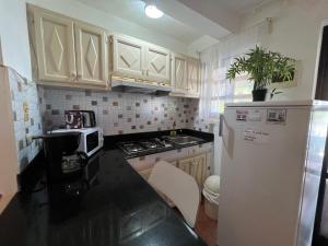 uma cozinha com armários brancos e uma geladeira branca em Condo 1bdr 1bth with garden em Punta Cana