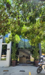 a scooter parked in front of a building with trees at Hotel Flores de Holambra in Holambra