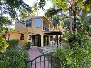 uma casa com um portão e palmeiras em Condo 1bdr 1bth with garden em Punta Cana