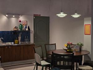 Dramatic Exit Bangkok - Cozy loft style near Suvarnabhumi Airport في بانكوك: غرفة طعام مع طاولة وكراسي ومطبخ