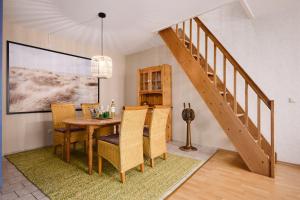 een eetkamer met een tafel en stoelen en een trap bij Deichweg 33 Käptns Kajüte in Kalifornien