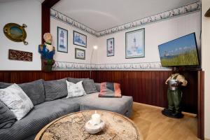 een woonkamer met een bank en een tafel bij Deichweg 33 Käptns Kajüte in Kalifornien