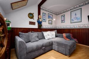 een woonkamer met een grijze bank in de hoek bij Deichweg 33 Käptns Kajüte in Kalifornien +24 foto's