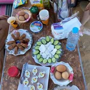 una mesa cubierta con platos de huevos y otros alimentos en Tours of the White Desert, en Az Zabū