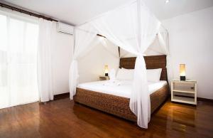 a bedroom with a bed with a canopy at Right along the shoreline ! in Boracay