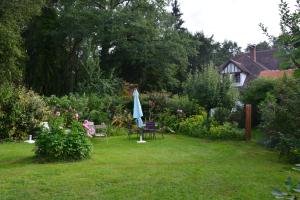 einen Garten mit einem Tisch und einem Regenschirm im Gras in der Unterkunft Chambre d'hôtes "Perle", Communs de Bon Hôtel in Ligny-le-Ribault + 3 Fotos