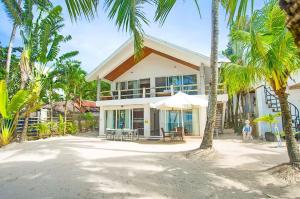 a woman standing in front of a house with palm trees at Right along the shoreline ! in Boracay