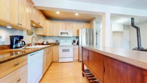 a large kitchen with wooden cabinets and white appliances at Western Slopes Villas #7 condo in Mammoth Lakes +14 photos
