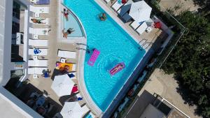 an overhead view of a swimming pool with people and umbrellas at Agrelli Hotel & Suites in Kardamaina