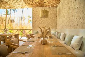 een eetkamer met een lange houten tafel bij Mawimbi Zanzibar in Paje