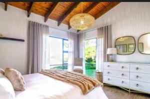a bedroom with a white bed and a large window at Oubaai golf eatate in Herolds Bay