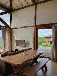 Serra, Beach tennis e Piscina في باتي دو ألفيريس: طاولة خشبية في غرفة مع نافذة كبيرة