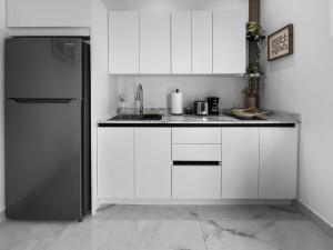 圣胡安Hyde Park 3 Comfy Apt With Parking in San Juan的配有白色橱柜和冰箱的厨房