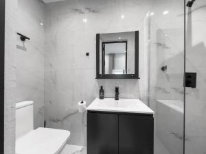 圣胡安Hyde Park 3 Comfy Apt With Parking in San Juan的浴室里有洗手池、马桶和镜子。