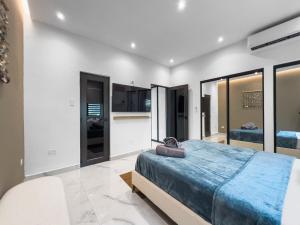 圣胡安Hyde Park 3 Comfy Apt With Parking in San Juan的一间卧室，里面有一张蓝色大床和玻璃窗。