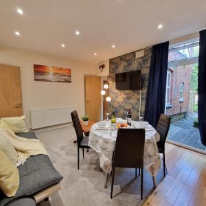 a living room with a dining room table with chairs at Coventry Retreat - Modern 2 Bed Apartment in Spon End