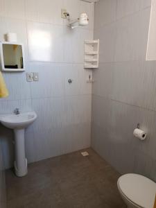a bathroom with a toilet and a sink at Pé na Terra - Suítes in São Miguel do Gostoso