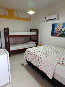 a bedroom with two beds and a bunk bed at Pé na Terra - Suítes in São Miguel do Gostoso