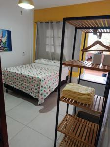 a bedroom with a bunk bed and a bed and a chair at Pé na Terra - Suítes in São Miguel do Gostoso