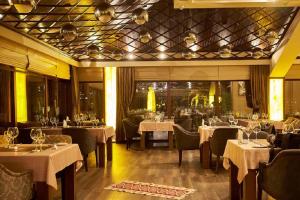 a restaurant with tables and chairs with white table cloth at Boulevard Side Hotel in Baku