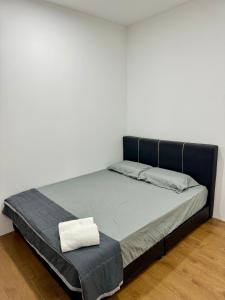a bed in a room with a white wall at Make Memories Escape 2BR Stay Summer Mall in Kota Samarahan