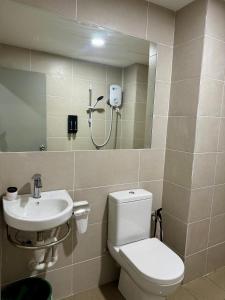 a bathroom with a toilet and a sink at Make Memories Escape 2BR Stay Summer Mall in Kota Samarahan +1 photo